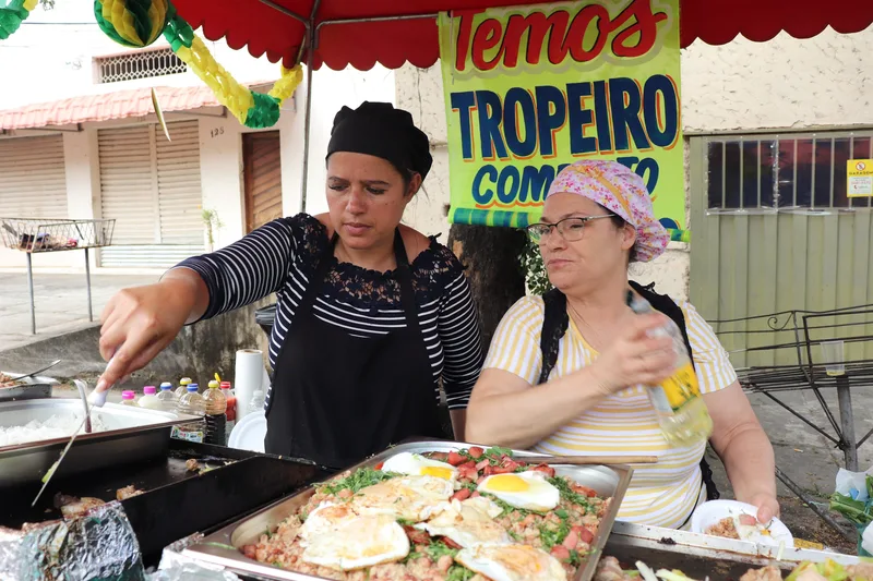 Cozinheiras preparando pratos na barraca do festival